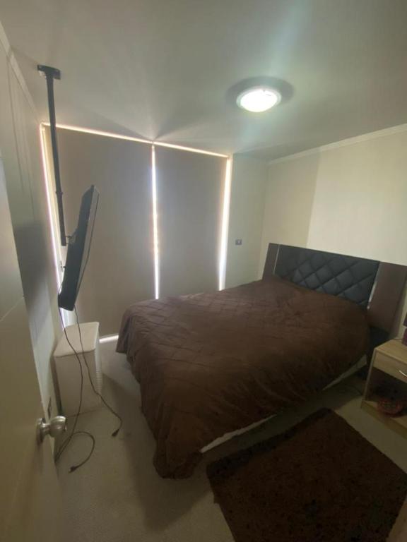 - une chambre avec un lit et une télévision à écran plat dans l'établissement Departamento diario Quilpue, à Quilpué
