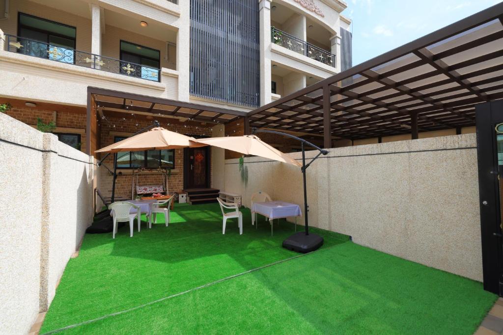 patio z zieloną trawą i parasolami w budynku w obiekcie Sunshine B&B w mieście Hualian