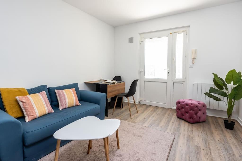 a living room with a blue couch and a table at Le Nirvana T avec salle de sport in Rouen