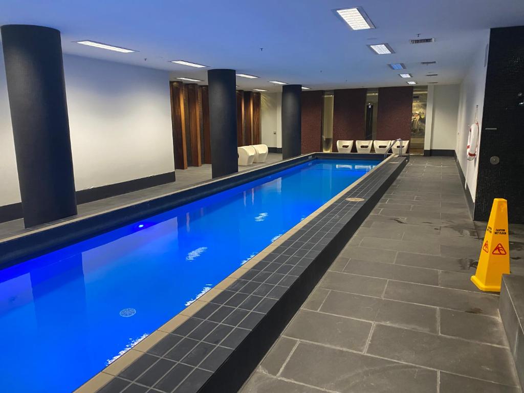 a swimming pool in a hotel with a yellow cone at Luxurious Apartment in the heart of Docklands in Melbourne