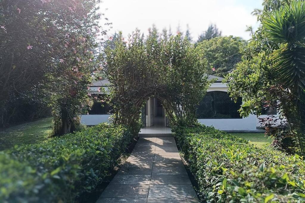 a garden with an archway and a white garage at Casa de campo centro Cotacachi. in Cotacachi