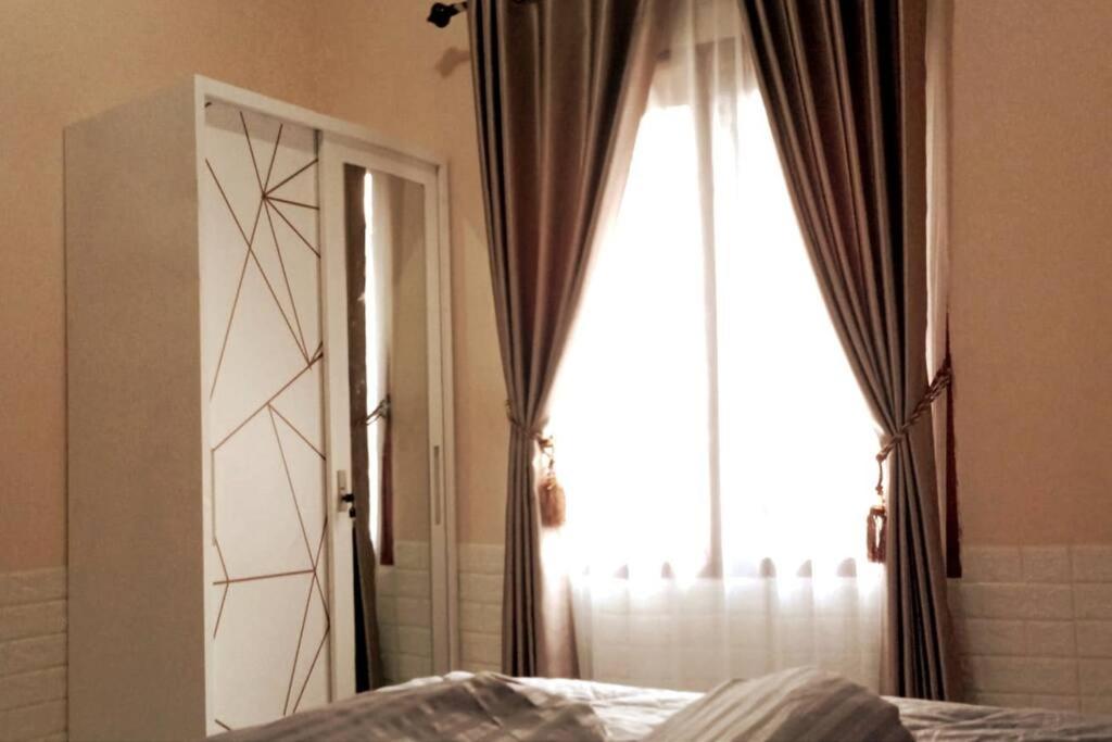 een slaapkamer met een raam, een bed en een spiegel bij Florence guest house mataram lombok in Mataram