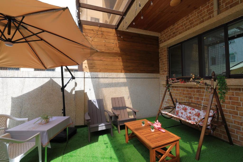 a patio with a swing and a table and an umbrella at Sunshine B&B in Hualien City