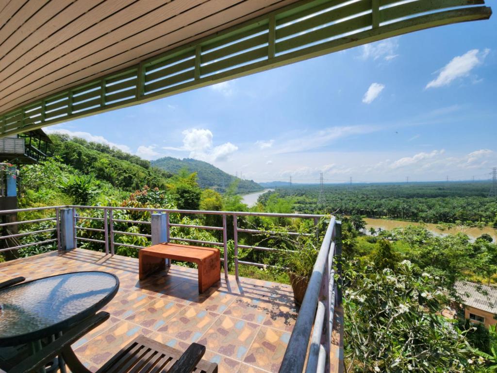 een uitzicht vanaf het terras van een huis met een tafel en stoelen bij Baan Khao Noi Resort in Suratthani