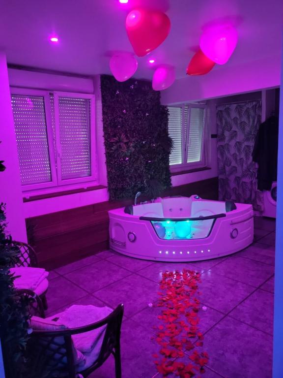 a room with a hot tub in a purple room at Jacuzzi Love room appartement Proche Paris in Rosny-sous-Bois