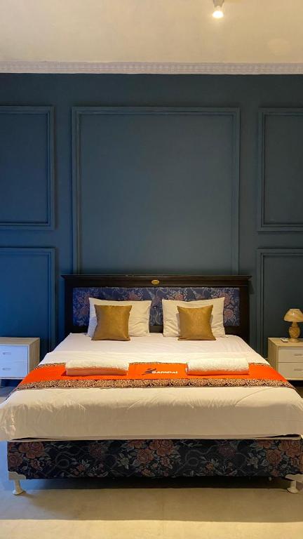 a bedroom with a large bed with blue walls at Omah Najwa by Sampai Coliving in Kejayan