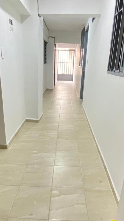 an empty hallway with a tile floor and a window at Restaurante y hospedaje La fonda in Santa Rosa de Cabal