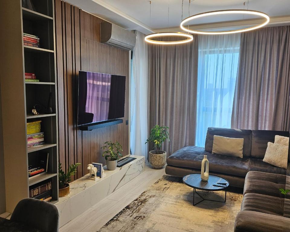 een woonkamer met een bank en een tv bij Stylish Loft in Onix Residence in Boekarest