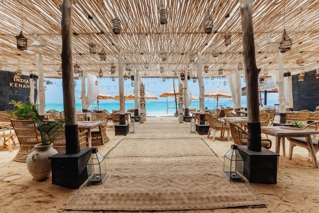 a restaurant on the beach with tables and chairs at Indiana Kenanga Boutique Hotel & Spa in Nusa Lembongan