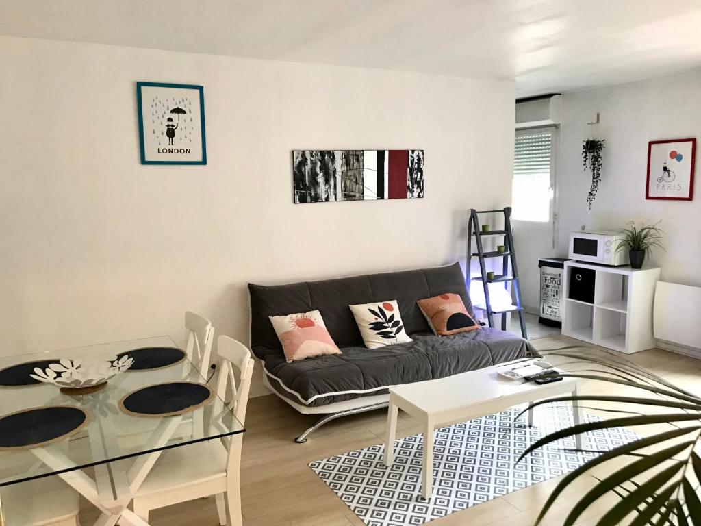 a living room with a couch and a table at cosy & pratique in La Plaine-Saint-Denis