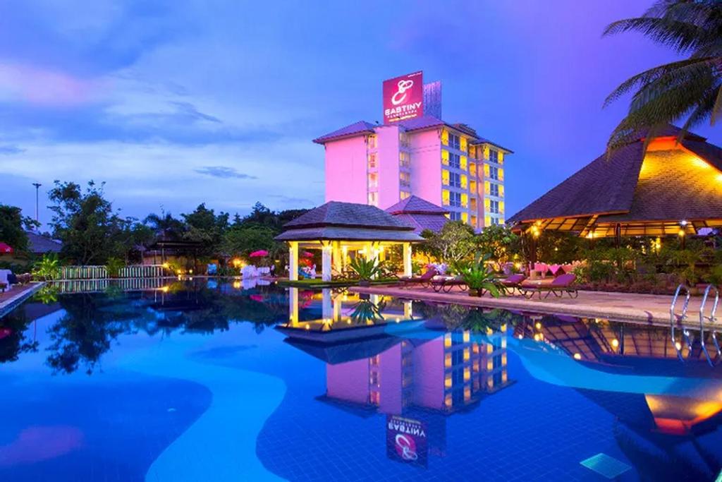 a hotel with a pool in front of it at Eastiny Resort & Spa in Nong Prue