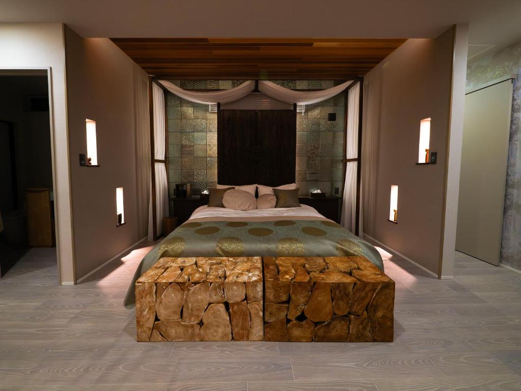 um quarto com uma cama grande com um tronco de árvore sidx sidx sidx em SWEET VILLA TAKASAMA 2 em Fujiyoshida