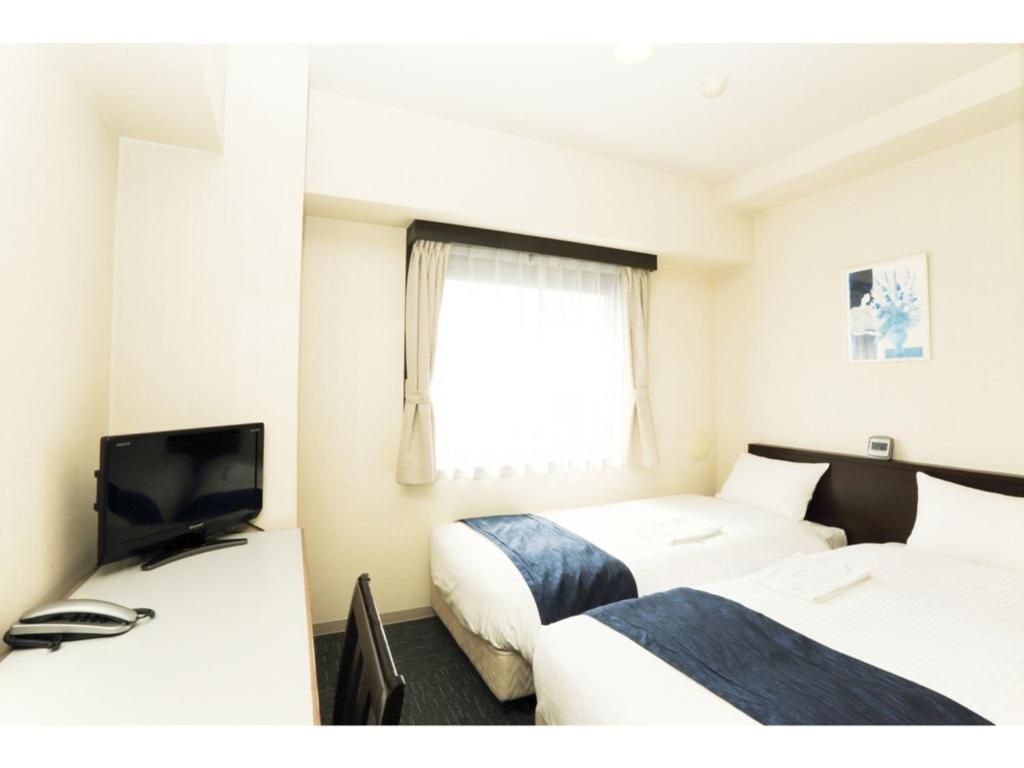 a hotel room with two beds and a television at Smile Hotel Asakusa - Vacation STAY 84954v in Tokyo