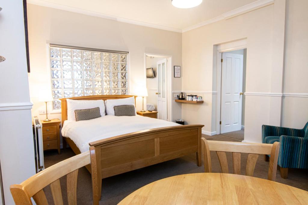 a bedroom with a bed and a table and a chair at The Grosvenor Plymouth in Plymouth