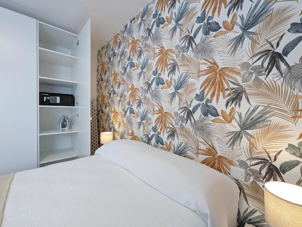 1 dormitorio con 1 cama con papel pintado tropical en La posada de Calixto, en Valdepeñas
