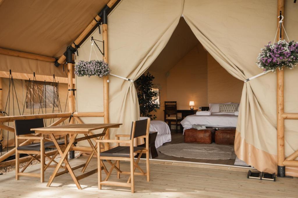 une tente avec une table, des chaises et un lit dans l'établissement Mia Glamping, à Orissaare