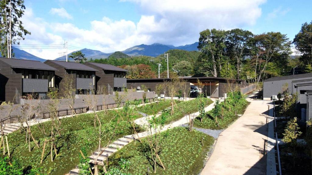 a garden with a pathway and some buildings and mountains at Rakuten Stay Villa 日光 in Nikko