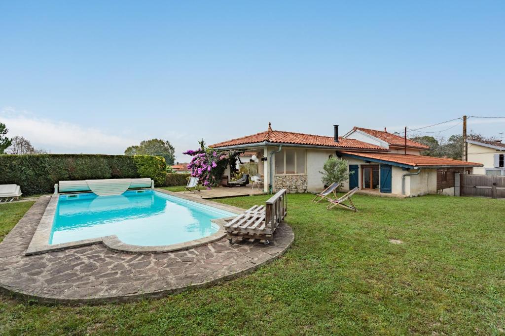 a swimming pool in the yard of a house at Villa Les Lys - Avec piscine et grand jardin in Sames