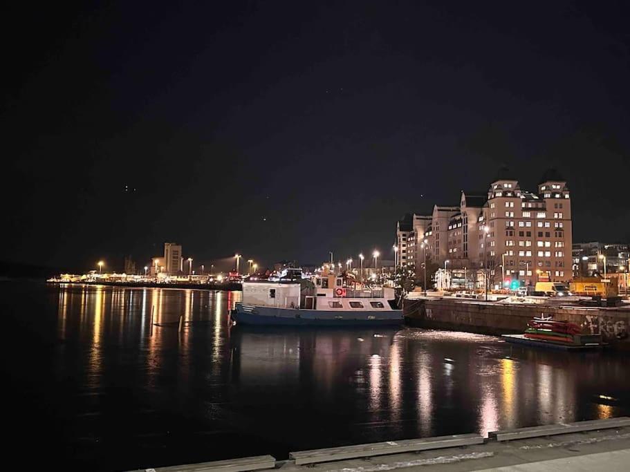 a boat is docked in a harbor at night at Amazing Studio by Royal Palace in Oslo