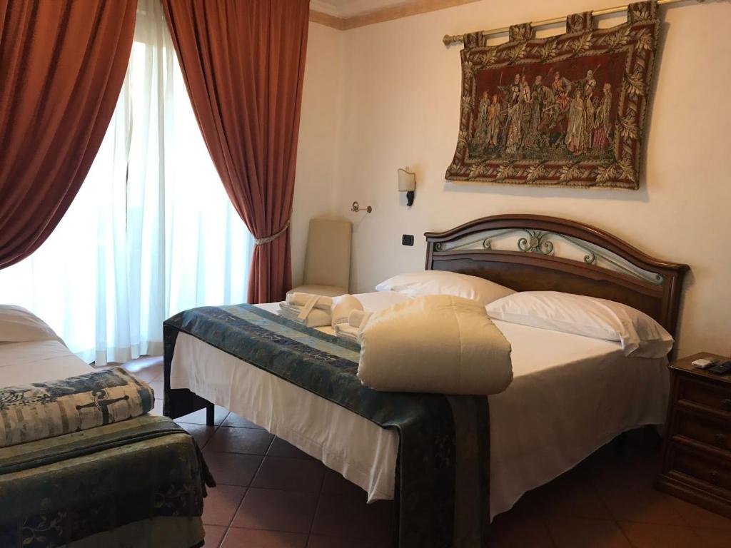 a bedroom with a bed and a painting on the wall at EURO HOUSE INN airport in Fiumicino