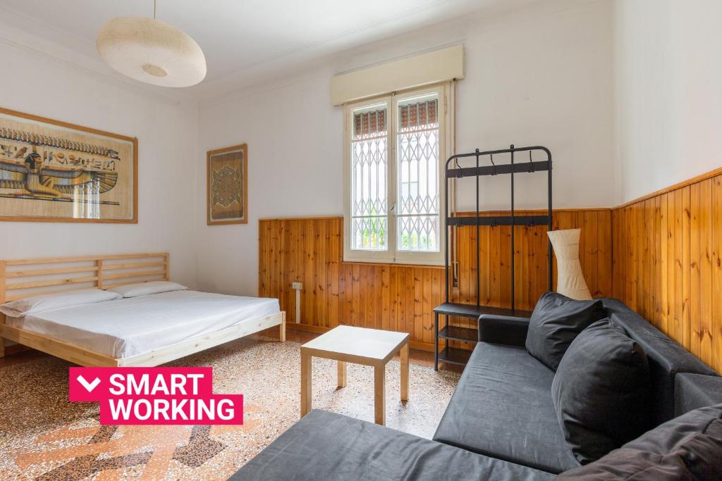 ein Wohnzimmer mit einem Bett und einem Sofa in der Unterkunft Sant'Orsola Apartment by Wonderful Italy in Bologna