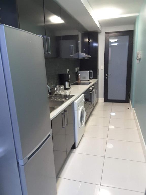 cocina con nevera y lavadora en City View Unit 130 at 77 on Independence en Windhoek