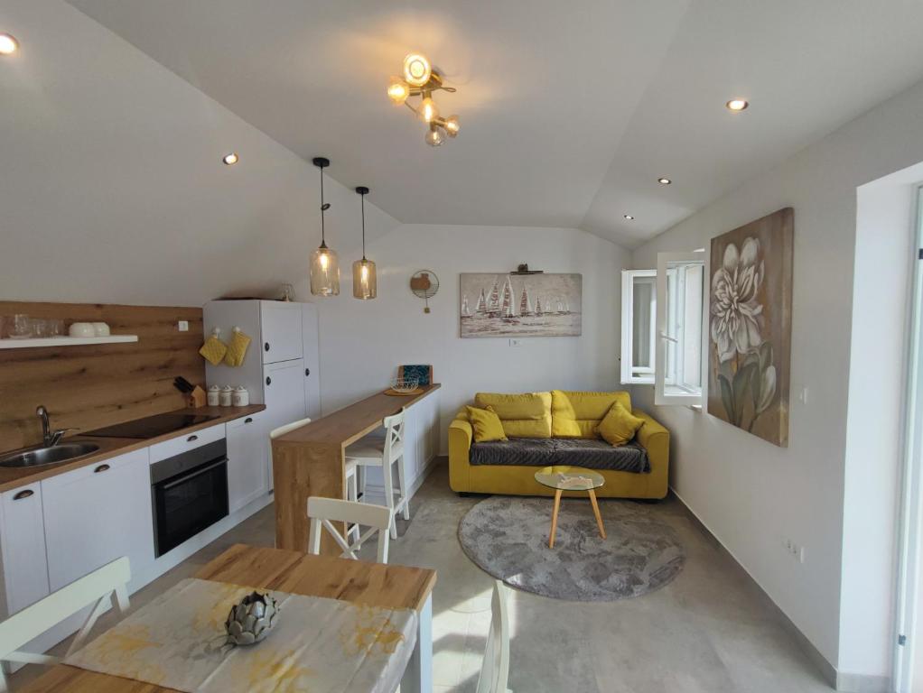 a kitchen and a living room with a yellow couch at Bobelino in Povlja
