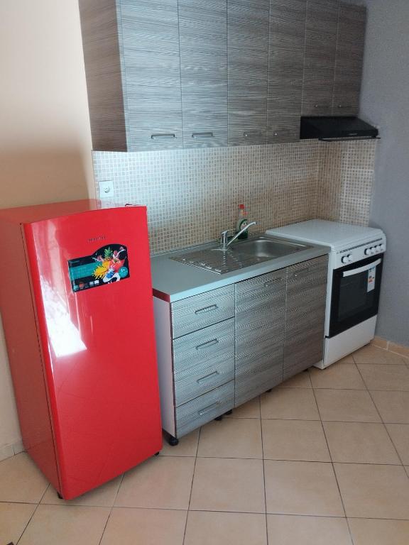 a kitchen with a red refrigerator and a sink at Cozy apartment in thessaloniki (1) in Thessaloniki