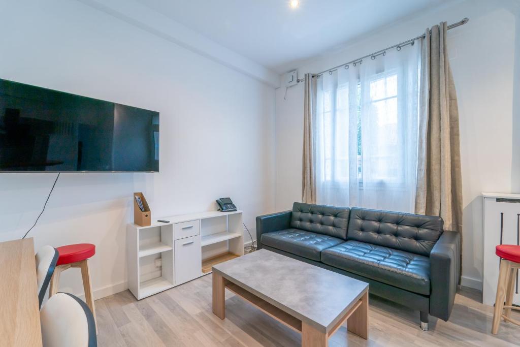ein Wohnzimmer mit einem Sofa und einem Tisch in der Unterkunft Le Sannoisien - Joli appt à proximité de Paris in Sannois