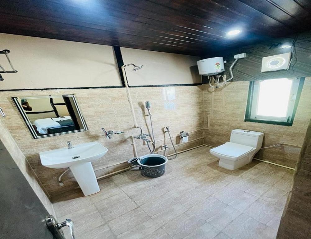 a bathroom with a sink and a toilet and a mirror at Daosri The Inn in Jyoti Gaon