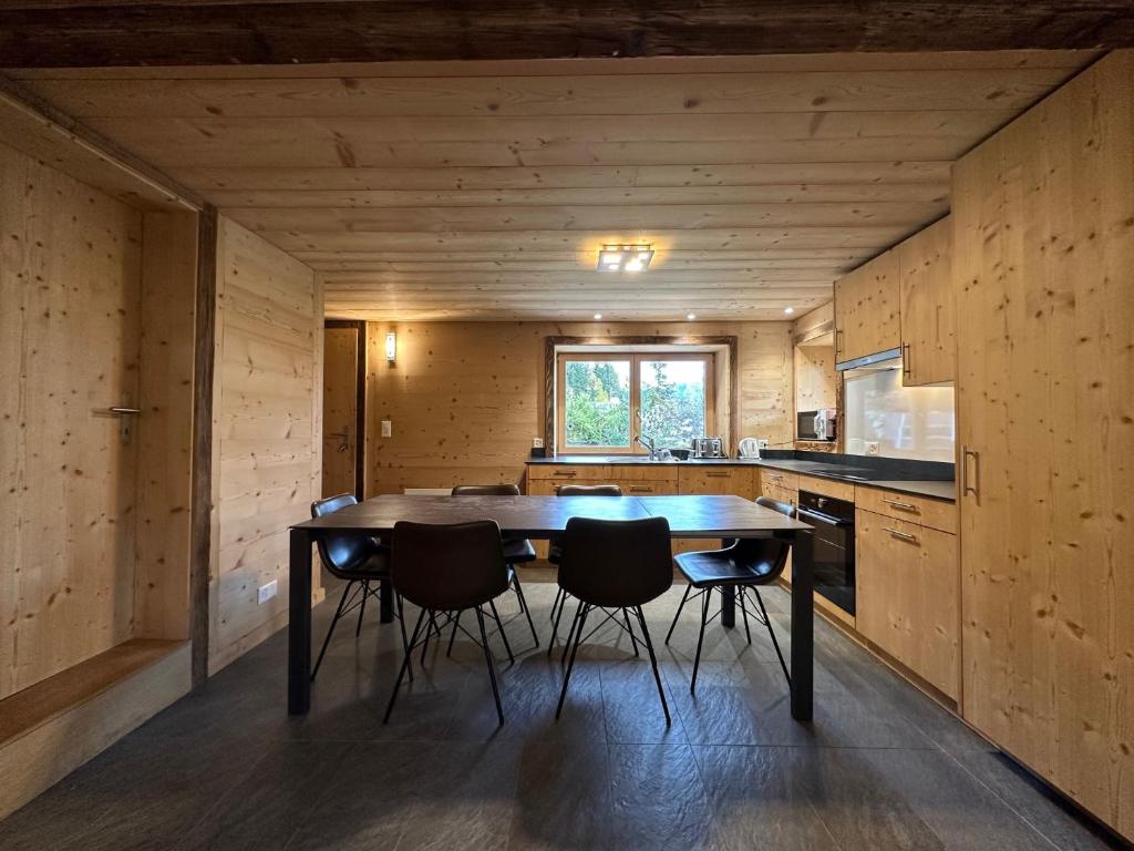 a kitchen with a table and chairs in a room at Chalet a Didi - Alps Paradise - 4 Vallees in La Tzoumaz