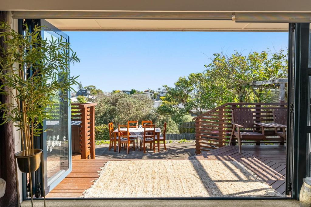 an open door to a patio with a table and chairs at Ultimate beach location in Mount Maunganui