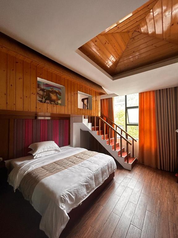 a bedroom with a large bed and a staircase at Family Hotel Zhangjiajie in Zhangjiajie