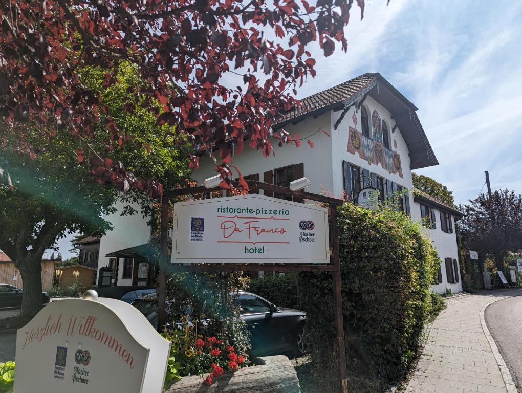 a sign in front of a house with a building at Hotel Ristorante Da Franco in Seefeld