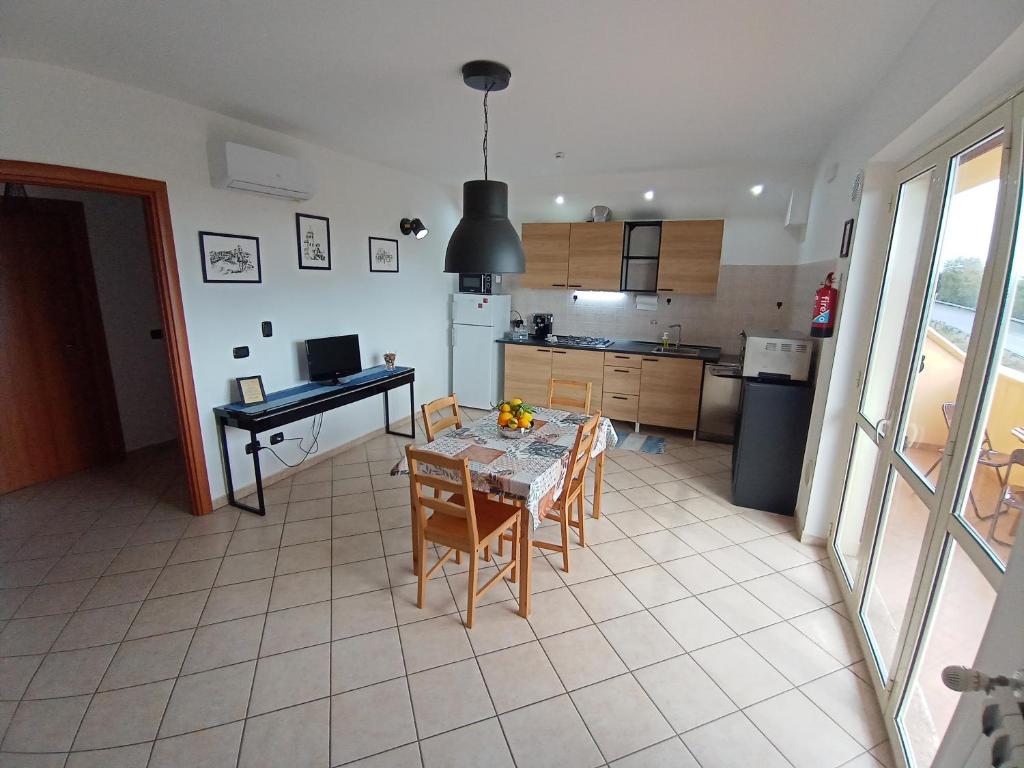 a kitchen and dining room with a table and chairs at Degli Angioini Holiday Home in Caulonia Marina