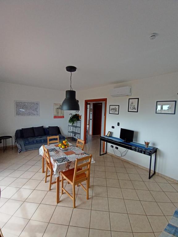sala de estar con mesa y sofá en Degli Angioini Holiday Home, en Caulonia Marina