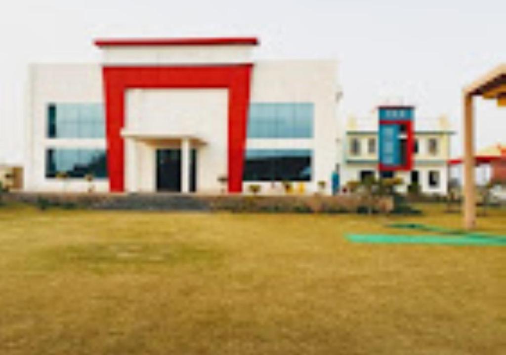 un gran edificio con una puerta roja en un campo en Sran Fort Palace Rajasthan, 