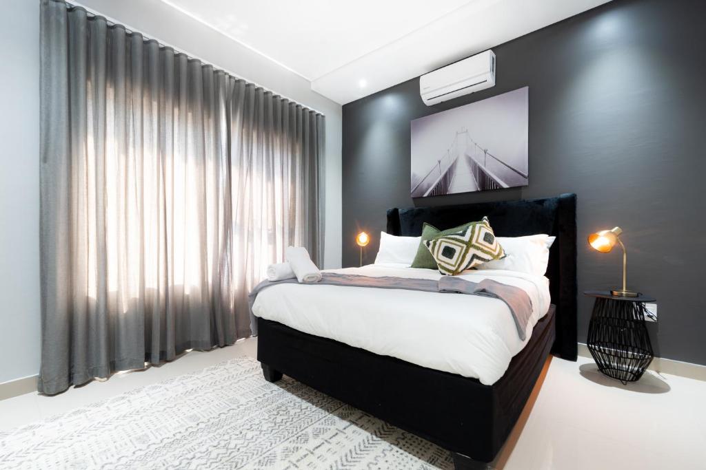 ein Schlafzimmer mit einem Bett und einem großen Fenster in der Unterkunft Reserved Suites Fourways in Sandton