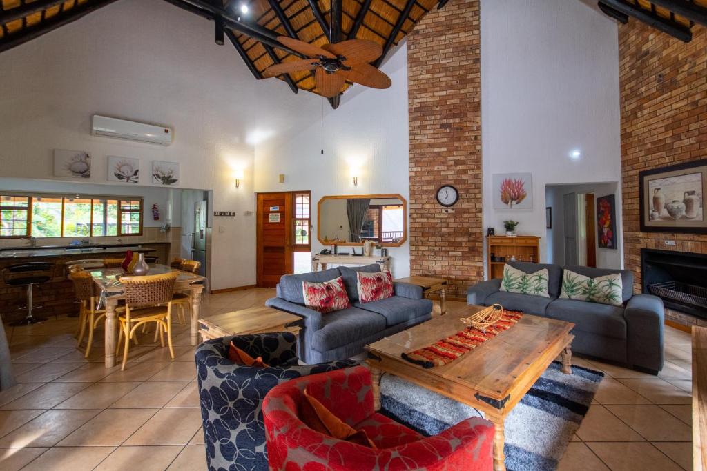a living room with couches and a table at Kruger Park Lodge Unit No. 239 in Hazyview