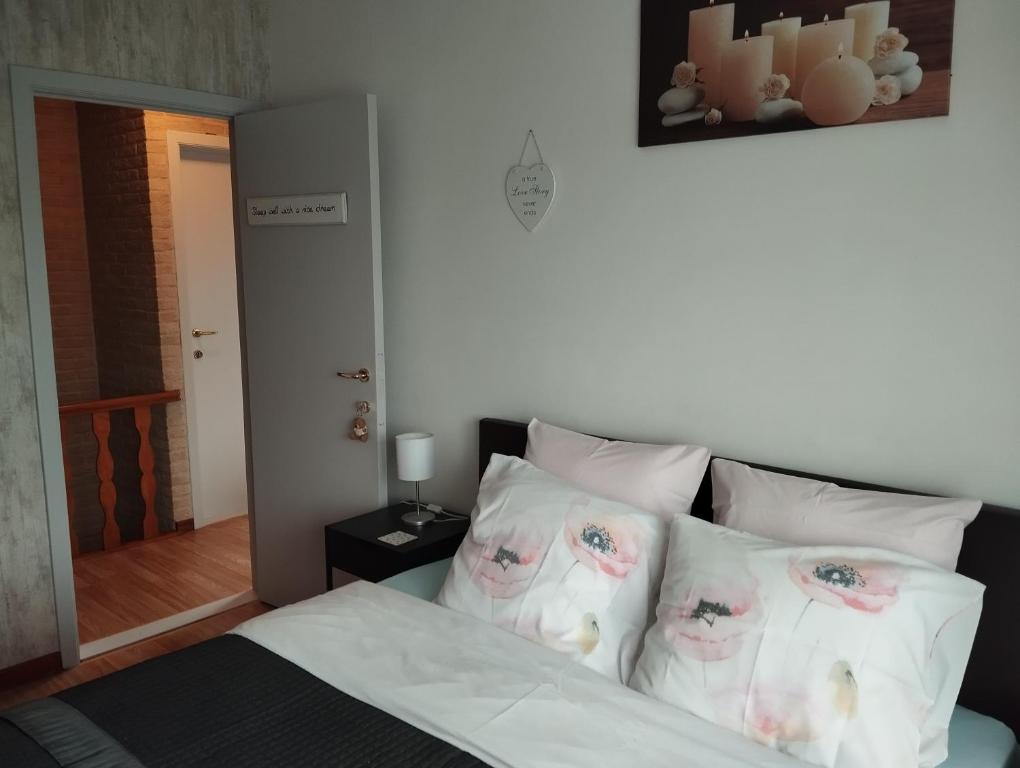 a bedroom with a bed with white sheets and pillows at Logies Lily in Oudenburg