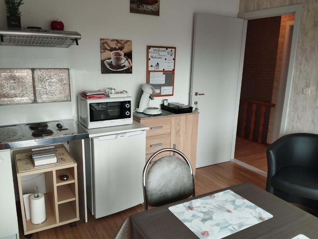 a small kitchen with a stove and a microwave at Logies Lily in Oudenburg