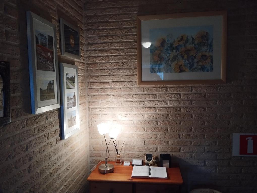 a desk with a lamp on a brick wall at Logies Lily in Oudenburg