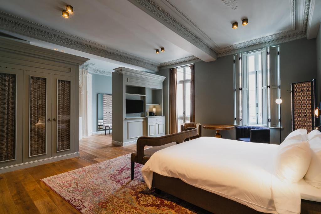 een slaapkamer met een bed en een woonkamer bij Hotel Monastère Maastricht in Maastricht