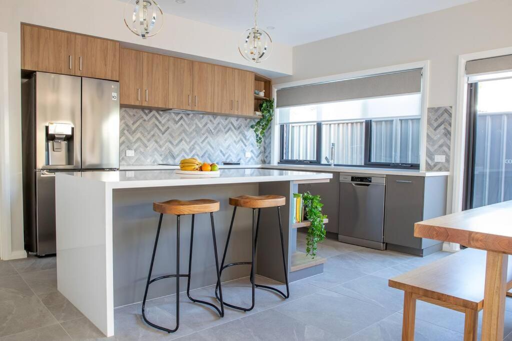 una cocina con encimera y taburetes. en The McKinlay Station View en Echuca