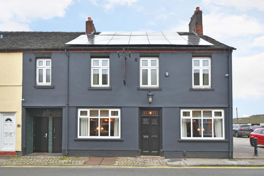 uma casa azul com janelas brancas em The Masons Arms em Newcastle under Lyme