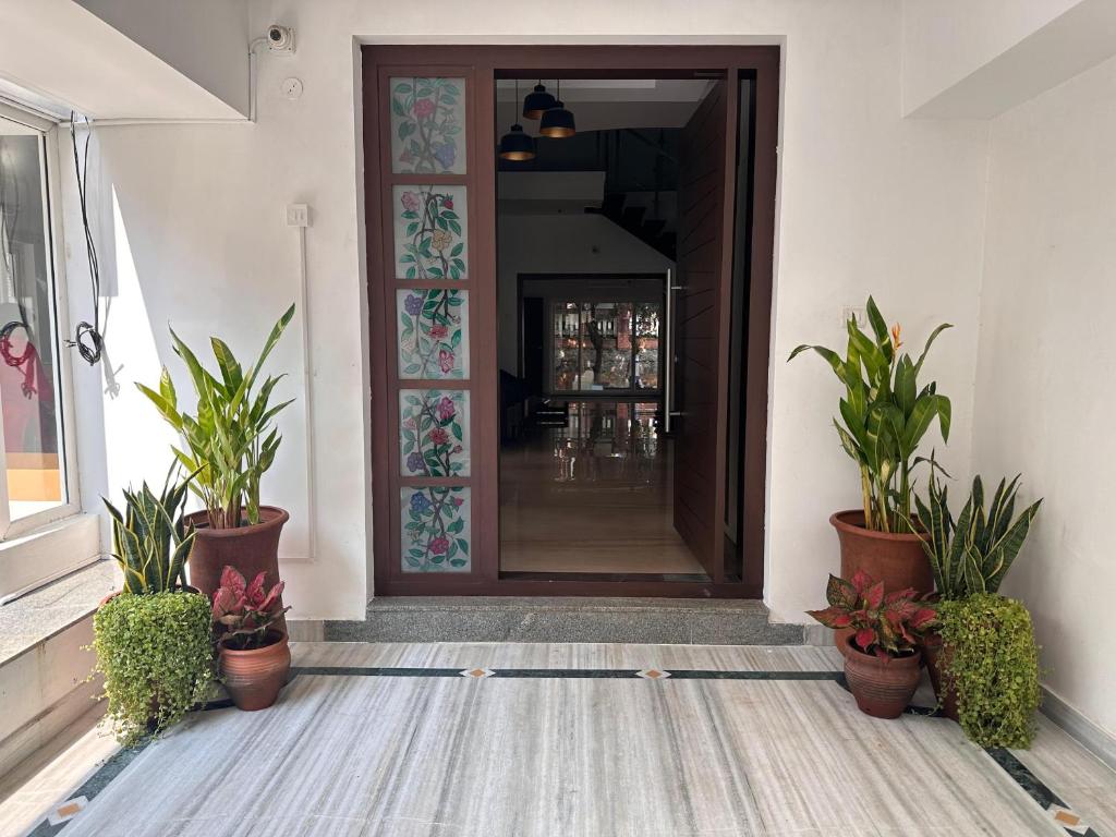 a hallway with potted plants in front of a door at Villa Ithaka by Youkoso in Chennai