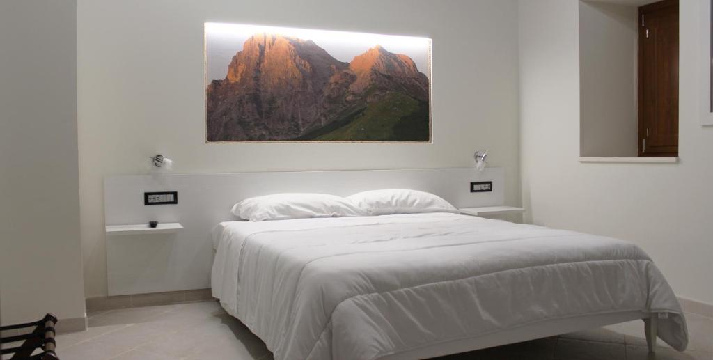 a bedroom with a bed with a picture on the wall at LA LOCANDA DA VITTORIO in Sassa