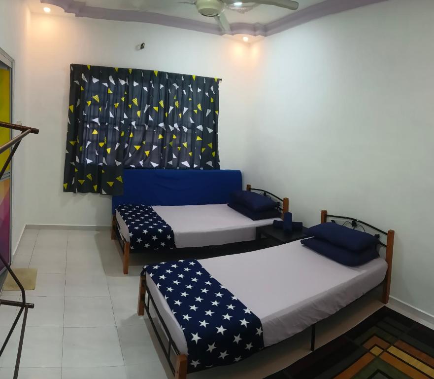 2 camas en una habitación con una bandera en la pared en Homestay No. 8, en Segamat