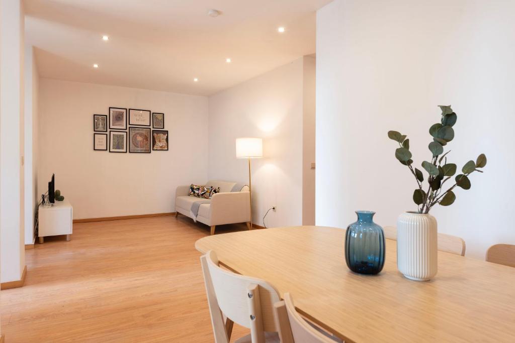 uma sala de estar com uma mesa e um sofá em ALTIDO Warm and Inviting flat with balcony no Porto