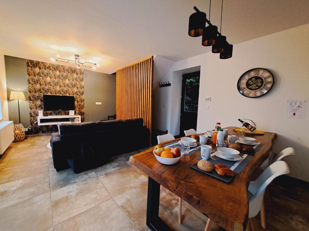 een woonkamer met een tafel met eten erop bij Gîte Chez Nénene La Roche en Ardenne in La-Roche-en-Ardenne